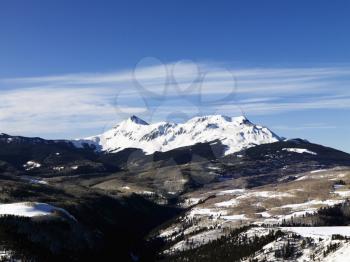 Aerial view of a snow-covered landscape with mountains and a valley. Horizontal shot.