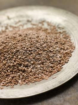 Royalty Free Photo of Brown Linseed on a Pewter Plate