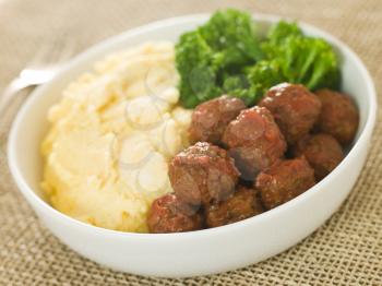 Royalty Free Photo of Tomato Meatballs With Parmesan Polenta and Broccoli