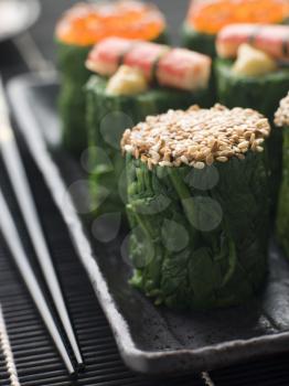 Royalty Free Photo of Rolled Spinach Three Ways-Snow Crab Toasted Sesame Seeds and Salmon Roe