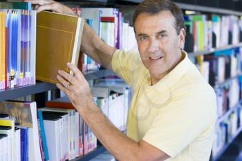 Royalty Free Photo of a Man Choosing a Book in a Library