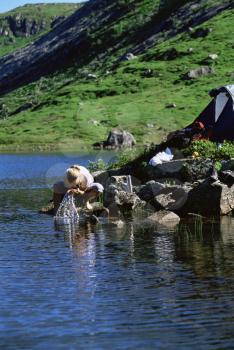 Royalty Free Photo of a Woman Washing Her Face in a Lake