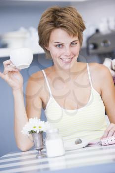 Royalty Free Photo of a Woman Sitting at a Table With Tea