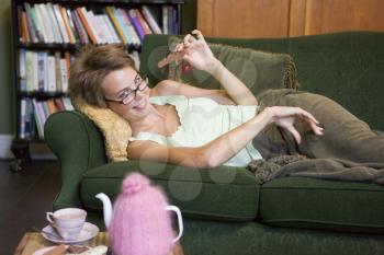 Royalty Free Photo of a Woman on a Sofa Eating Chocolate