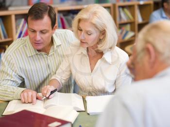 Royalty Free Photo of Three People Working in a Library