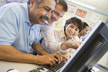 Royalty Free Photo of Students and a Teacher at Computers