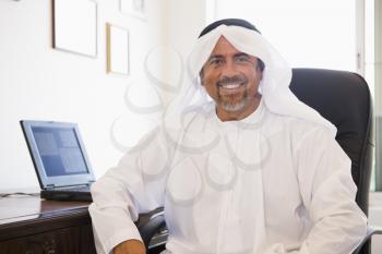 Royalty Free Photo of a Man in an Office With a Laptop