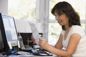 Royalty Free Photo of a Woman at the Computer With Paper