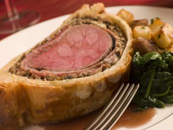 Royalty Free Photo of Beef Wellington With Roasted Potatoes and Spinach