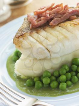 Royalty Free Photo of Roasted Cod Fillet with Mashed Potato Peas and Bacon