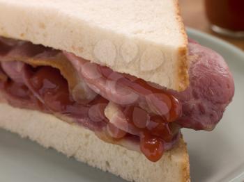 Royalty Free Photo of a Bacon Sandwich on White Bread with Tomato Ketchup