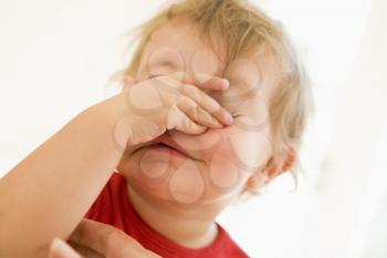 Royalty Free Photo of a Baby Putting Her Hand Over Her Face