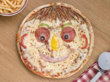 Royalty Free Photo of a Smiley Faced Pizza With a Portion of Chips