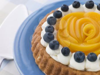 Royalty Free Photo of a Whipped Cream Peach and Blueberry Sponge Flan