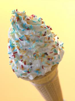 Royalty Free Photo of a Whipped Ice Cream Cone With Candy Sprinkles