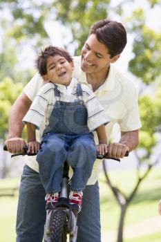 Royalty Free Photo of a Man and Boy on a Bike