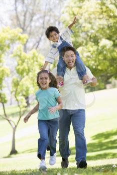 Royalty Free Photo of a Man Running With Two Children