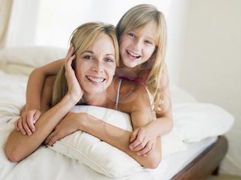 Royalty Free Photo of a Woman and Girl on a Bed