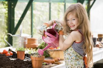 Royalty Free Photo of a Young Girl Watering a Plant