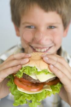 Royalty Free Photo of a Boy Eating a Cheeseburger