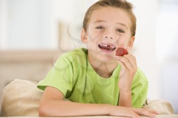 Royalty Free Photo of a Boy Eating a Strawberry