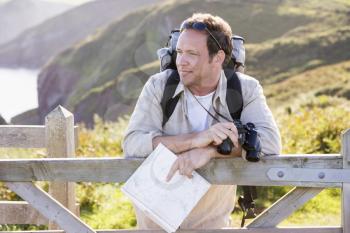 Royalty Free Photo of a Man on a Cliff Leaning on a Fence