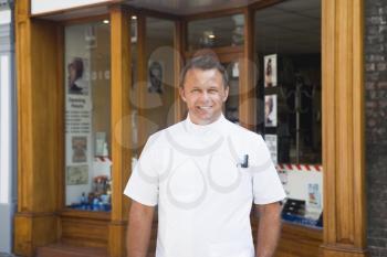 Royalty Free Photo of a Barber Outside His Shop