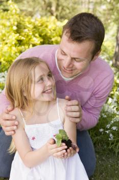 Royalty Free Photo of a Father and Daughter With a Plant