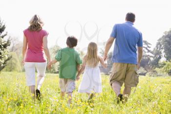 Royalty Free Photo of a Family Walking in a Field of Flowers