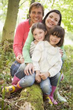 Royalty Free Photo of a Family Sitting on a Log