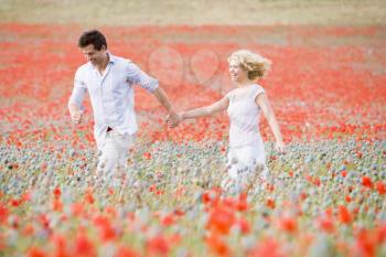Royalty Free Photo of a Couple Walking in a Poppy Field