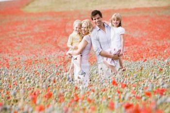 Royalty Free Photo of a Family Standing in a Poppy Field