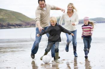 Royalty Free Photo of a Family Playing Soccer at the Beach