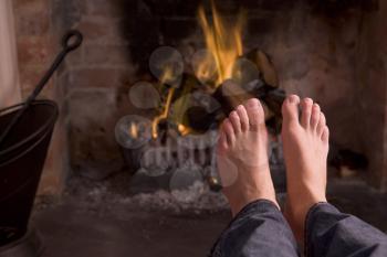 Royalty Free Photo of a Man's Feet Warming at the Fire