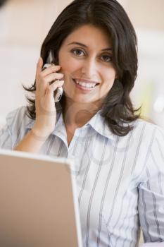Royalty Free Photo of a Woman at the Laptop Talking on a Phone