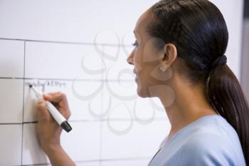 Royalty Free Photo of a Woman Writing on a Whiteboard