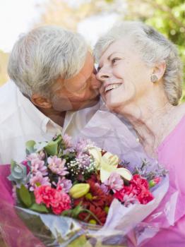 Royalty Free Photo of a Man Giving His Wife Flowers