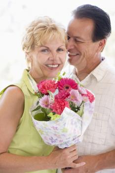 Royalty Free Photo of a Man Giving His Wife Flowers