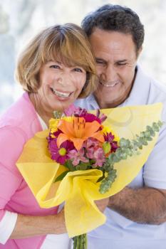 Royalty Free Photo of a Man Giving His Wife Flowers