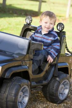 Royalty Free Photo of a Little Boy in a Toy Jeep