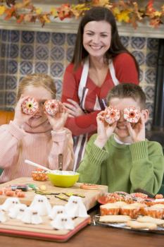 Royalty Free Photo of a Mother and Two Children With Halloween Treats