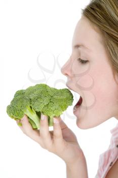 Royalty Free Photo of a Teenager Eating Broccoli