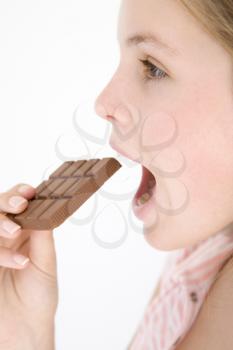 Royalty Free Photo of a Girl Eating a Chocolate Bar