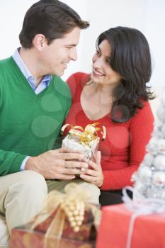 Royalty Free Photo of a Man Giving His Wife a Christmas Gift