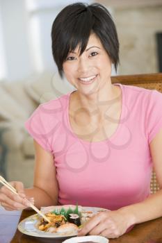 Royalty Free Photo of a Woman Eating With Chopsticks