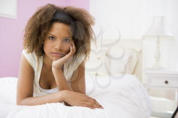 Royalty Free Photo of a Sad Girl Lying on a Bed