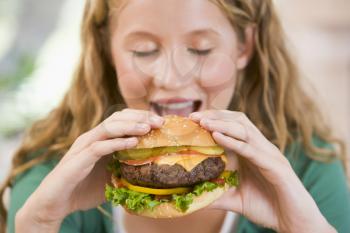 Royalty Free Photo of Girl Eating a Burger
