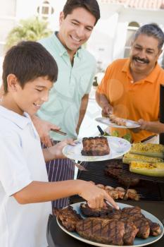 Royalty Free Photo of Three Generations of Men Barbecuing