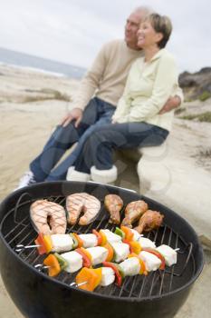 Royalty Free Photo of a Couple Cooking on a Barbecue at the Beach