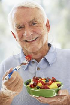 Royalty Free Photo of a Man Eating a Fruit Salad